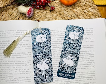 May include: Two blue and white bookmark designs featuring a rabbit and a fox with floral patterns. The bookmarks are made by Space Bird Crafts.