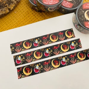 Op de afbeelding: Drie rollen washi tape met een donkere achtergrond en een herhalend patroon van manen, paddenstoelen en flesjes met toverdrank. De tekst op de tape luidt "Magic Mushroom" en "Sparrow Bird Crafts".