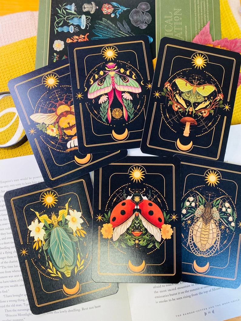 Peut inclure: Six cartes illustr&eacute;es avec un fond noir et des accents dor&eacute;s. Chaque carte pr&eacute;sente un insecte ou une cr&eacute;ature diff&eacute;rent, notamment un papillon de nuit, une coccinelle, une abeille et un scarab&eacute;e. Les cartes font partie d'un ensemble d'illustrations plus large.