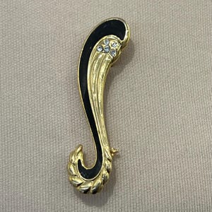 Pretty delicate gold toned and black diamonte swirl brooch