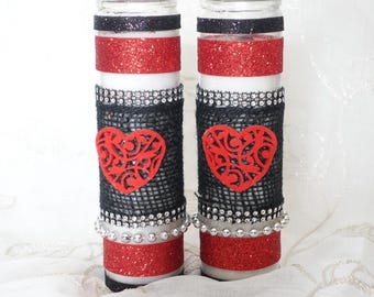 May include: Two decorative glass candle holders. Each has a black glitter band at the top, a red glitter band, and a black mesh section with a red heart. Silver beaded accents and a red glitter base complete the design.