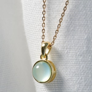 necklace with a gold pendant and an aqua chalcedony.