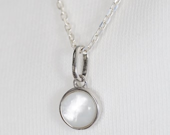 Natural white mother-of-pearl cabochon necklace with silver chain and pendant. Minimalist summer jewelry inspired by the sea.