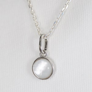 Natural white mother-of-pearl cabochon necklace with silver chain and pendant. Minimalist summer jewelry inspired by the sea.