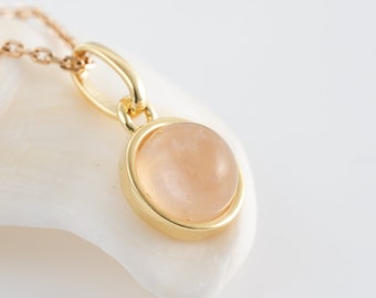Natural rose quartz necklace in cabochon, chain and golden pendant. Minimalist jewelry for women.