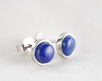 Könnte beinhalten: Ein Paar silberne Ohrstecker mit runden blauen Lapislazuli-Steinen.
