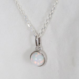 Può includere: Una collana con catena d'argento con un ciondolo di opale bianco.