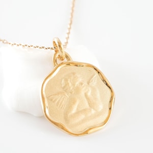 Round golden angel necklace, gold-plated pendant and chain, angel with two wings, delicate jewelry to offer for Christmas.