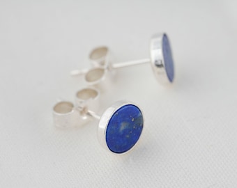 Könnte beinhalten: Ein Paar silberne Ohrstecker mit runden blauen Lapislazuli-Steinen.