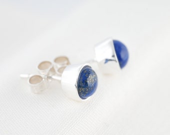Könnte beinhalten: Ein Paar silberne Ohrstecker mit blauen Lapislazuli-Edelsteinen. Die Edelsteine haben eine gesprenkelte Optik.