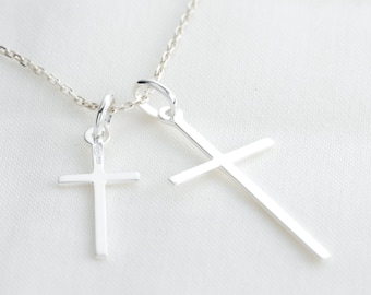 Colgante cruz cristiana (cruz latina) en plata, una pequeña y otra grande, joyería cristiana minimalista.