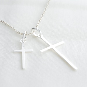 Christlicher Kreuzanhänger (lateinisches Kreuz) aus Silber, ein kleiner und ein großer, minimalistischer christlicher Schmuck.
