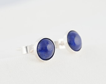 Könnte beinhalten: Ein Paar silberne Ohrstecker mit runden blauen Lapislazuli-Steinen.