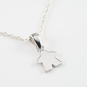 Könnte beinhalten: Eine silberne Halskette mit einem Anhänger in Form einer Spielfigur. Der Anhänger trägt die Nummer "925" auf der Rückseite.