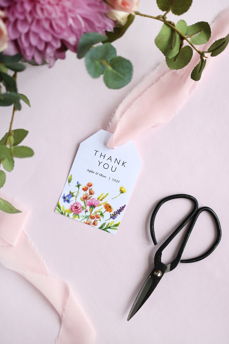 May include: White thank you tag with a floral design and the text "THANK YOU" in black. Below the text is "Sophie & Oliver | 5.9.23" in black.