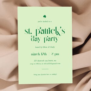 May include: Green and white St. Patrick's Day party invitation with a shamrock icon. The invitation includes the text "you're invited to a st. patrick's day party", "hosted by Olivia & Emily", "march 17th 2 pm", "123 shamrock way boston, ma", "rsvp to Olivia at olivia123@gmail.com", and "bring your favorite beer or whiskey!"
