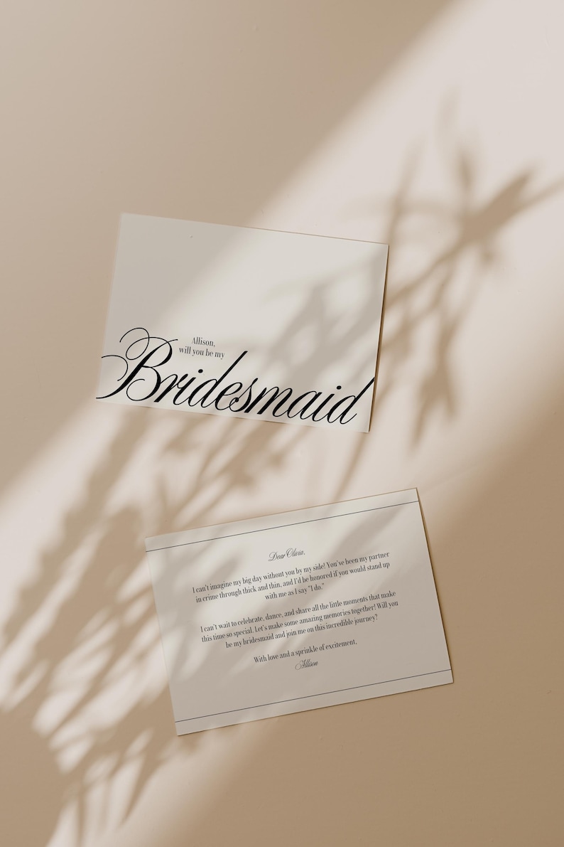 May include: Two white cards with black text. The top card reads "Allison, will you be my Bridesmaid" in elegant script. The bottom card contains a longer message with a decorative border. The cards are on a neutral background with shadows.