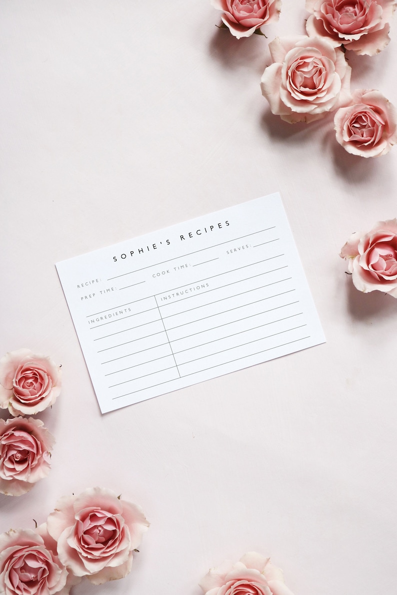 May include: A white recipe card with the title "Sophie's Recipes" and headings for "Recipe", "Prep Time", "Cook Time", "Instructions", "Ingredients", and "Serves". The card is surrounded by pink roses.