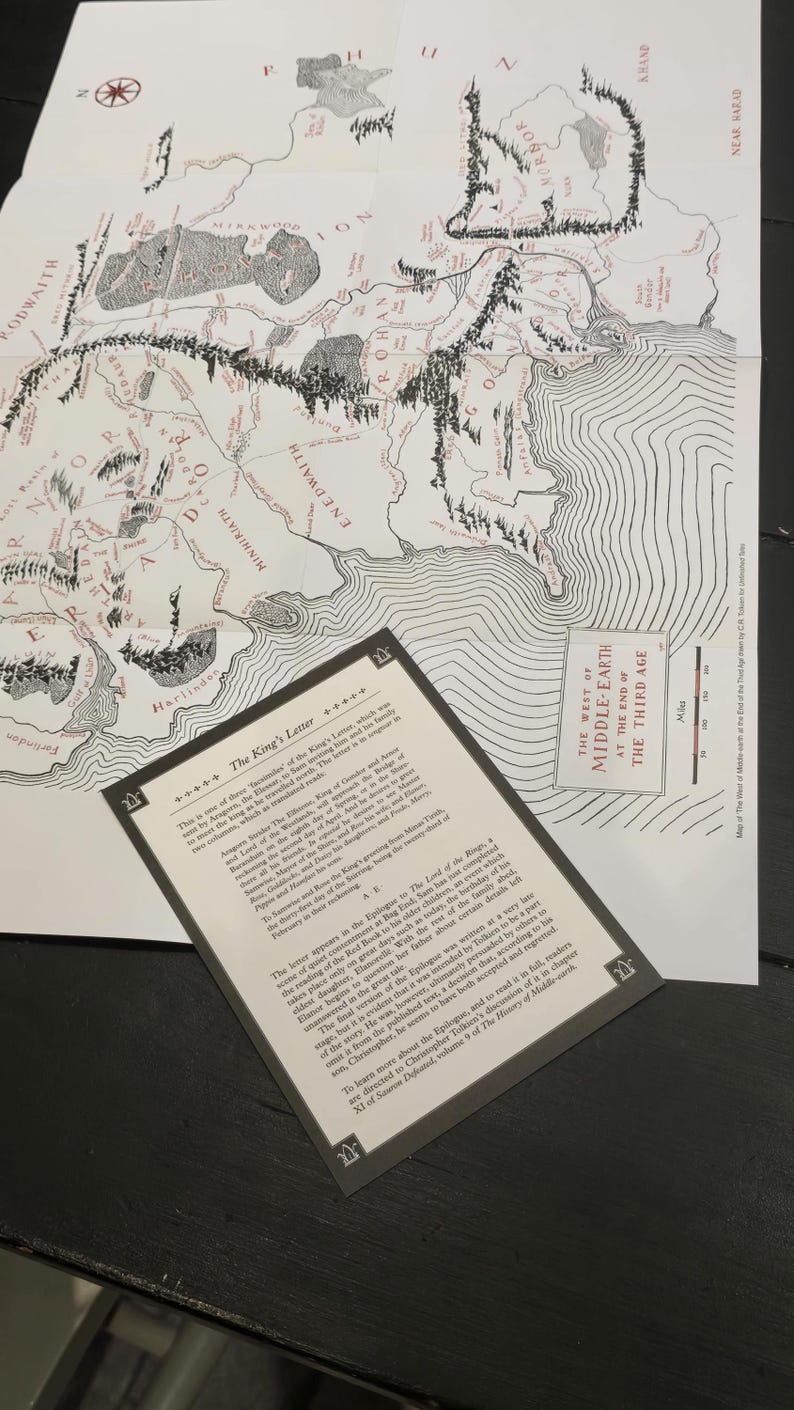 Pode incluir: Um mapa preto e branco da Terra-m&eacute;dia de O Senhor dos An&eacute;is, com um close-up de um trecho de texto do ep&iacute;logo do livro. O texto explica que o ep&iacute;logo foi escrito pelo filho de J.R.R. Tolkien, Christopher Tolkien, ap&oacute;s a morte de seu pai.