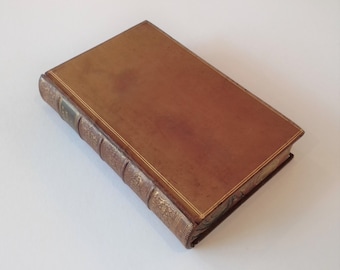 May include: A brown leather-bound book with gold accents and a decorative pattern on the spine.