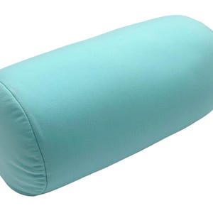 May include: A cylindrical bolster pillow in a solid, light teal color. The pillow is made of a soft fabric and is designed for comfort and support. The pillow is approximately 12 inches long and 6 inches in diameter.