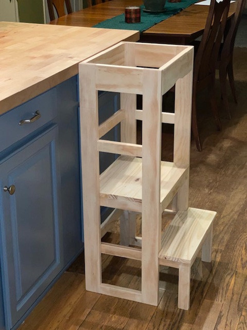 Puede incluir: Un taburete de madera con cuatro pelda&ntilde;os y una plataforma superior. El taburete est&aacute; hecho de madera sin tratar y tiene un color natural. Est&aacute; dise&ntilde;ado para ayudar a los ni&ntilde;os a alcanzar superficies m&aacute;s altas.