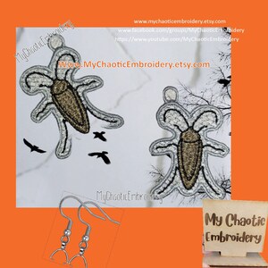 Peut inclure: Deux boucles d'oreilles brodées argentées et brunes représentant un insecte. Les boucles d'oreilles sont suspendues à des crochets argentés. L'image comprend également le texte "My Chaotic Embroidery" et l'adresse du site Web "www.MyChaoticEmbroidery.etsy.com".