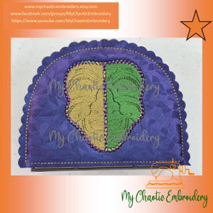 May include: A purple, half-circle clutch with a gold and green embroidered design. The design is a split face. The clutch has a scalloped edge and the text "My Chaotic Embroidery" is visible. Website information is also visible.
