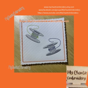 Puede incluir: Dos carretes de hilo bordados sobre un fondo de tela blanca. Los carretes son grises con hilo verde y azul. El texto "My Chaotic Embroidery" es visible en las esquinas superior izquierda e inferior izquierda de la imagen.