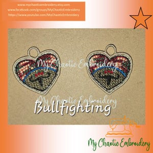 May include: Two red, white, and blue heart-shaped ornaments with a bull's head design in the center. The ornaments are embroidered with a brown, green, and blue design. The text "My Chaotic Embroidery Bullfighting" is printed below the ornaments.