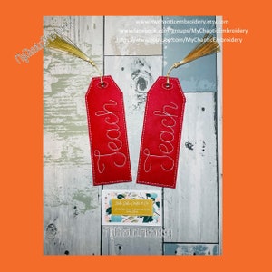 May include: Two red fabric bookmarks with gold tassels. The bookmarks are rectangular and have the word "Teach" embroidered in white thread.