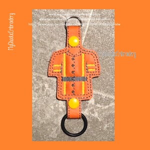 May include: Orange and yellow firefighter keychain with a black metal ring. The keychain is made of leather and has a button closure. The text "MyChaoticEmbroidery" is visible on the keychain.