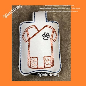 May include: White key fob in the shape of a veterinarian's uniform, featuring brown stitching and a black paw print. The key fob has a blue border and includes the text "MyChaoticEmbroidery".