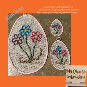 Puede incluir: Tres adornos ovalados bordados con flores rosas, azules y moradas. Los adornos están sobre un fondo marrón. El texto "My Chaotic Embroidery" es visible en la esquina inferior derecha.