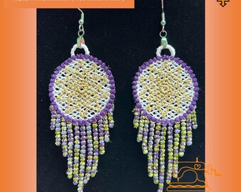 May include: A pair of purple and gold dreamcatcher earrings with a fringe of beads. The earrings are hanging from silver hooks.