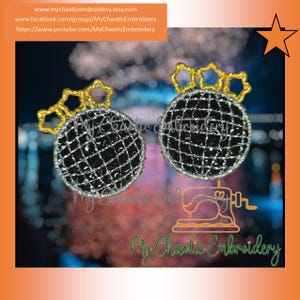May include: Pair of black and silver embroidered ornaments with a grid pattern, topped with gold starburst designs. The ornaments are displayed against a blurred background. The text "My Chaotic Embroidery" is visible.