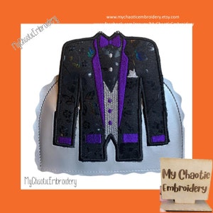 May include: A black and purple embroidered patch of a tuxedo jacket with a bow tie. The patch is on a silver background with a scalloped edge. The text "My Chaotic Embroidery" is visible at the bottom of the image.