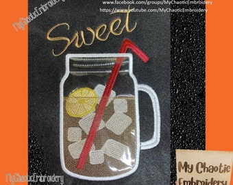 May include: Embroidered design of a mason jar filled with iced tea, a lemon wedge, and a red straw. The jar has a white handle and is on a black background. The text "Sweet" is above the jar in gold embroidery. The text "My Chaotic Embroidery" is at the bottom of the design.