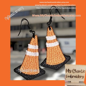 May include: A pair of orange and white traffic cone earrings with black detailing. The earrings are hanging from black hooks. The earrings are on a white background with the text "My Chaotic Embroidery" in the bottom right corner.