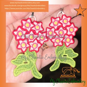 May include: Embroidered floral earrings featuring clusters of red and white flowers with yellow centers and green leaves. The earrings are handmade and have a delicate, detailed design. The text "My Chaotic Embroidery" is visible.