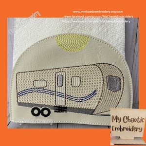 May include: Embroidered design of a beige camper with blue stripes and a yellow sun on a white background. The design is stitched on a white fabric. The text "My Chaotic Embroidery" is visible in the bottom left corner of the image.
