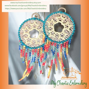 May include: A pair of colorful crocheted earrings with a beaded fringe. The earrings are circular with a star-shaped cutout in the center. The fringe is made of beads in shades of red, orange, yellow, green, blue, and turquoise.
