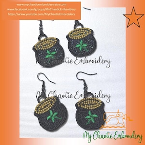 May include: A pair of gold and black pot of gold earrings with a shamrock design. The earrings are hanging from black hooks. The earrings are on a white background with the text "My Chaotic Embroidery" on the bottom.