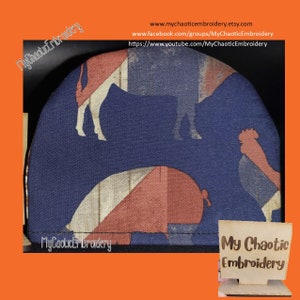 May include: A blue and red fabric pot holder with a Union Jack pattern and silhouettes of farm animals. The pot holder has the text "My Chaotic Embroidery" on the bottom.