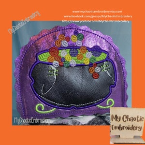 Puede incluir: Caldero de fieltro morado con un borde verde lleno de cuentas de colores. El caldero está sobre un fondo morado con el texto "My Chaotic Embroidery" en verde.