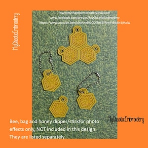 Może przedstawiać: Cztery żółte, haftowane breloczki w kształcie plastra miodu z srebrnymi łańcuszkami. Breloczki mają kształt sześciokąta i są ozdobione haftem w kolorze żółtym i czerwonym. Tekst "MyChaoticEmbroidery" jest widoczny w prawym dolnym rogu obrazu.