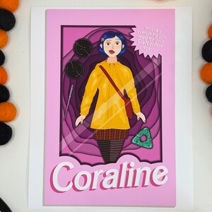 Może przedstawiać: R&oacute;żowa kartka z wyciętym papierowym obrazkiem Coraline z filmu Coraline. Lalka ma na sobie ż&oacute;łty płaszcz przeciwdeszczowy, czerwoną torebkę i sp&oacute;dnicę w kratę. Na kartce widnieje tekst "Zawiera wszystko, czego potrzebujesz do swoich WŁASNYCH guzikowych oczu!" i "Coraline".