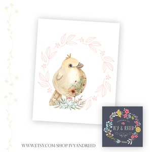 Puede incluir: Una ilustraci&oacute;n de acuarela de un p&aacute;jaro amarillo con flores rosas en el pecho, sentado en un lecho de hojas verdes y flores azules. El p&aacute;jaro est&aacute; rodeado de una corona floral rosa.