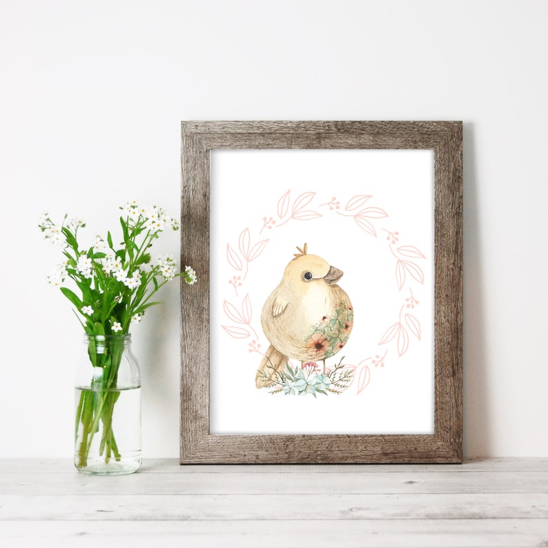 Puede incluir: Una ilustraci&oacute;n de acuarela de un p&aacute;jaro amarillo con una corona de flores a su alrededor. El p&aacute;jaro est&aacute; de pie sobre un lecho de flores y hojas. El fondo es blanco.