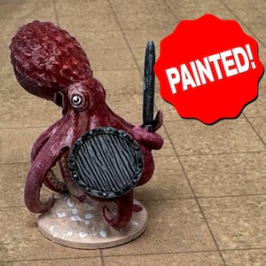 May include: A painted miniature of an octopus warrior, holding a sword and shield. The octopus is a deep red color, with a detailed texture. The shield is round with a wooden design. The text "PAINTED!" is on a red starburst.